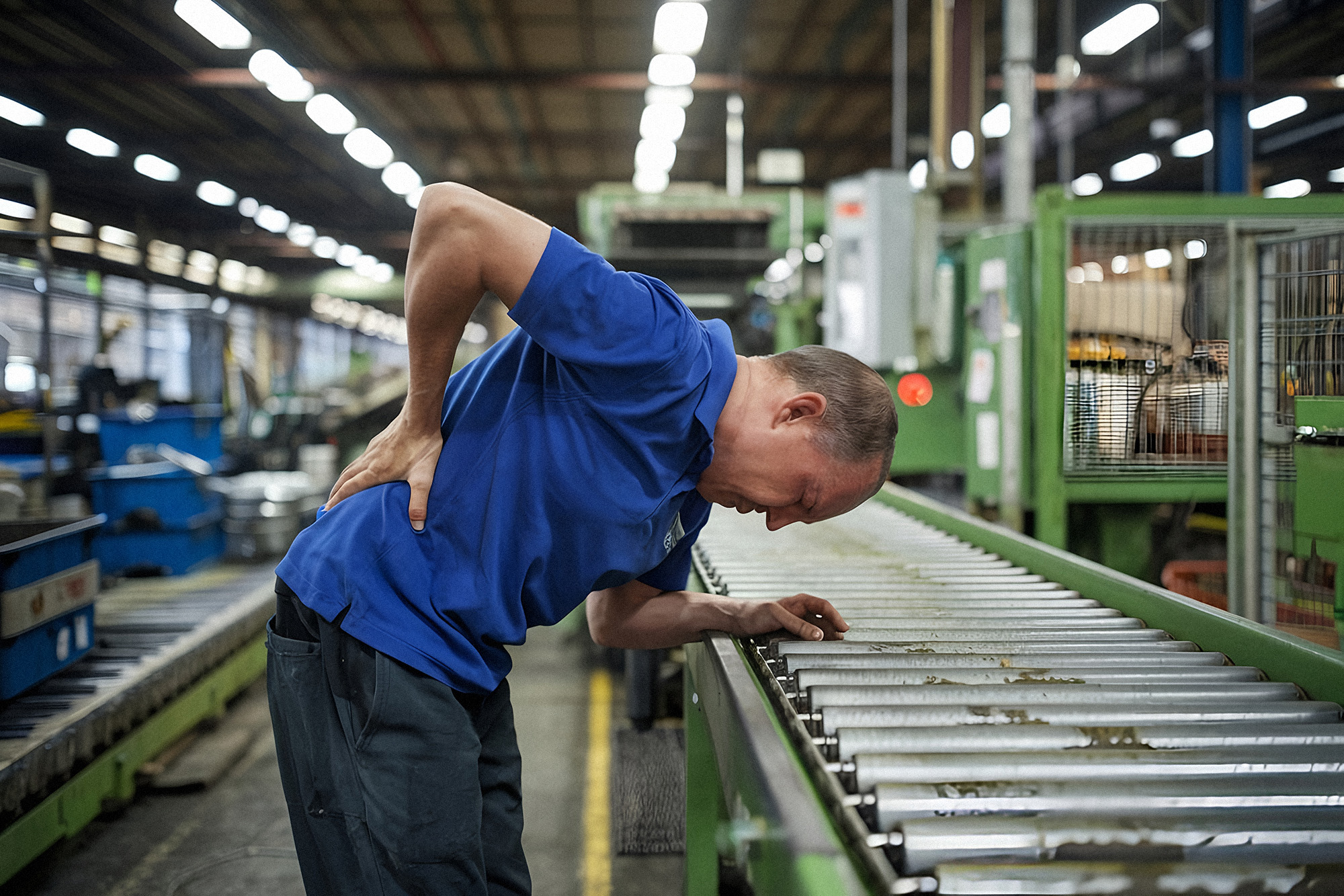 Man in Factory Suffering from Back Pain