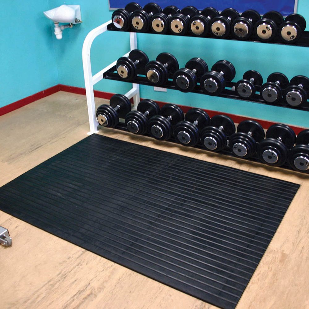 Rack-of-dumbbells-placed-beside-a- black-rubber-Weightroom-mat-on-a- wooden-floor