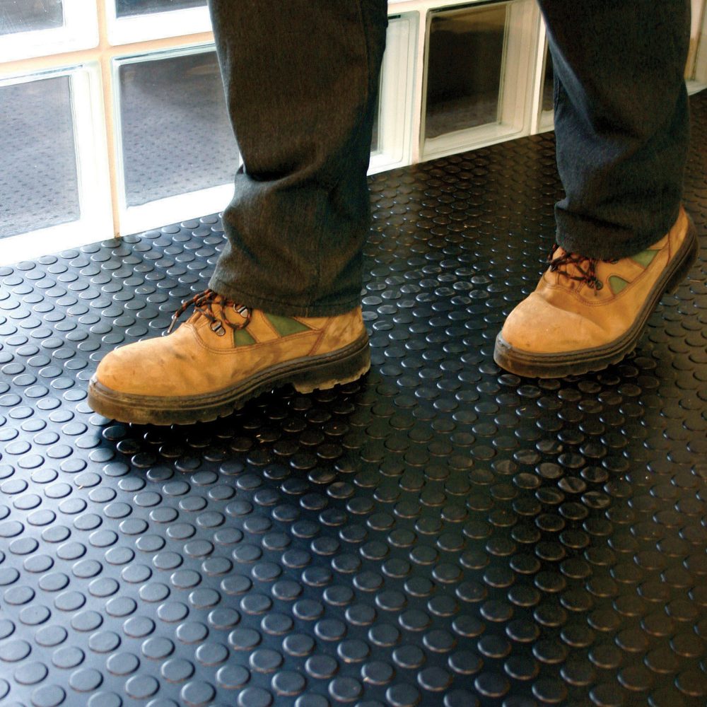 Person-walking-over-a-heavy-duty- black-rubber-COBAdot-anti-fatigue- mat