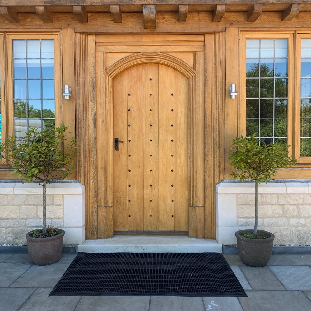 Image-of-a-black-rubber-Entramat- placed-outside-a-house-doorway-on-a-patio-flooring