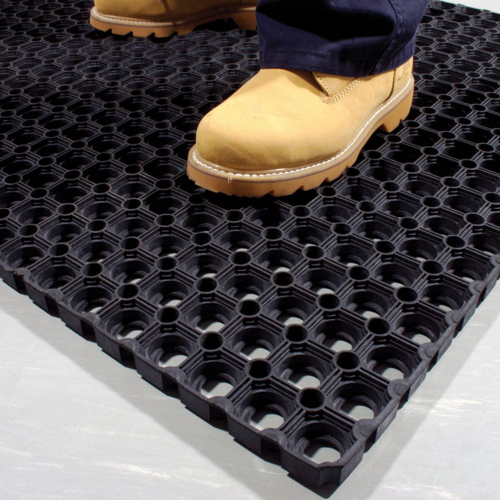 Close-up-image-of-a-person-standing- on-a-black-rubber-Ringmat- Honeycomb-placed-on-a-white-floor