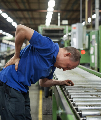 Man in Factory Suffering from Back Pain